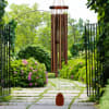 Copper wind chime hanging in a garden walkway