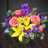Bright yellow lilies burst amid pink roses and ruffled carnations in a