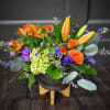 A brightly colored centerpiece designed with lilies, alstromeria, spray roses and more!
