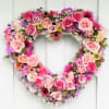 Heart-shaped floral wreath with pink roses and mixed blooms