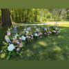 Low floral arrangements in pastel colors placed outdoors on grass