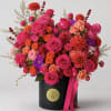 Bright mixed bouquet in a black hatbox with a pink ribbon
