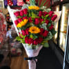 A front-facing cascading bouquet wrapped in floral paper and finished with a