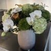 White orchids and pale green hydrangeas in a silver vase