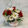 Red roses and white daisies in a baseball-shaped vase