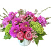 Pink and magenta flowers arranged in a ribbed white vase