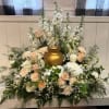 White and blush floral arrangement around a gold urn