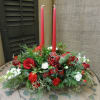 Red and white floral centerpiece with two tall red candles