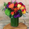 Colorful bouquet with calla lilies, roses, and hydrangea in a green vase