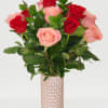 Bouquet of red and pink roses in a tall glass vase