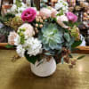 Mixed pink and white flowers in a white vase with succulents