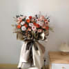 Large bouquet of peach and pink roses with paper wrapping