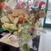 Pastel bouquet of roses, lilies, and hydrangeas in a glass vase