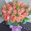Pink rose bouquet in a glass vase with a lavender ribbon