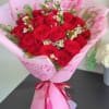 Bouquet of red roses wrapped in pink paper with a ribbon