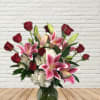 Bouquet of red roses and pink lilies in a glass vase