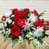 Red and white mixed flower arrangement with daisies and roses