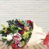 Mixed bouquet with lilies, roses, and chrysanthemums wrapped in paper