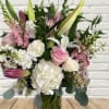 Pink and white bouquet with lilies and roses in a glass vase