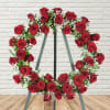 Heart-shaped wreath of red roses on a metal stand