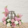 Pink and white floral arrangement around a silver urn