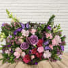 Mixed bouquet of pink and purple flowers with butterfly accents