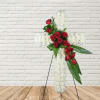 White floral cross with red roses on a stand