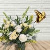 White and pale yellow flower arrangement with a butterfly decoration