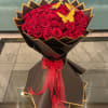 Bouquet of red roses wrapped in black paper with a red ribbon
