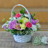 Mixed flower basket with roses, carnations, and daisies in a white wicker basket