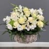 White and cream floral arrangement in a wicker basket