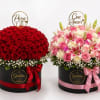 Two round flower boxes with red roses and pink mixed blooms