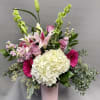 Tall pink and white mixed flower arrangement with hydrangea, lilies, and gerbera daisies in a pink vase