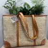 Woven tote bag with tan leather straps and trim