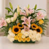 Arrangement of pink lilies, sunflowers, and cream roses in a rectangular vase