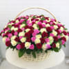 Large basket of red, white, and pink roses arranged densely in a white wicker basket