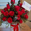 Bouquet of red roses in a clear glass vase with a birthday card