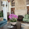 Pink orchid arrangement in a stone bowl on a coffee table
