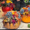 Pumpkin arrangements with colorful flowers and autumn foliage