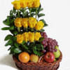 Yellow roses arranged in a basket with assorted fruit