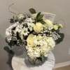 Elegant white hydrangeas, white roses, daisies and baby&rsquo;s breath arranged in a