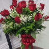 A lush cluster of two dozen deep red roses arranged with delicate