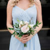 Woman holding a pale pink and white bridal bouquet