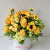 Yellow roses and sunflowers arranged in a white vase