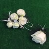 White rose corsage and matching boutonniere on green grass