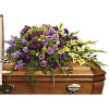 Purple and yellow floral spray on a wooden casket