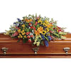Colorful floral spray on a wooden casket