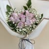 Lavender roses with baby's breath in white wrapping
