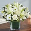 White lilies and roses in a square glass vase