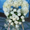 Heart-shaped white rose and hydrangea floral wreath on an easel